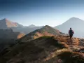 Wędrowiec na grani Tatr, odkrywa malownicze tatry szlaki dla średnio zaawansowanych. Słońce oświetla zbocza.