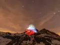 Górski szczyt, niczym polski Matterhorn, rozświetlony nocą polskimi barwami pod rozgwieżdżonym niebem.
