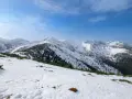 Śnieżny szlak na Grzesia w Tatrach. W oddali widać ośnieżone szczyty i lasy.