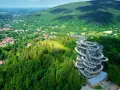 Widok na wieżę widokową w otoczeniu lasów i miasteczka. Idealne miejsce, gdzie w góry można wybrać się na spacer i podziwiać panoramę.