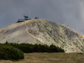 Schronisko i obserwatorium na szczycie w Karkonoszach, z widoczną kolejką linową i kamienistym zboczem.