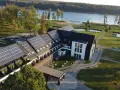 Nowoczesny hotel z panelami słonecznymi nad jeziorem, idealny na Mazury all inclusive.