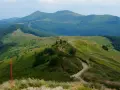 Malownicze szlaki górskie, zielone wzgórza i odległe pasma górskie. Wspaniałe atrakcje w górach dla każdego miłośnika wędrówek.