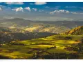 Widok na Tatry z ośnieżonymi szczytami, w tym Trzy Korony. Jesienne wzgórza pokryte złotymi liśćmi i zielonymi łąkami.