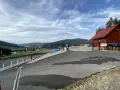 Widok na parking przy górze Żar. W oddali widać zabudowania i góry.