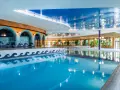 Basen Tropikana Mikołajki: cennik i atrakcje. Woda w basenie lśni, odbijając światła i architekturę.