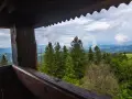 Widok z drewnianej wieży widokowej na górzysty krajobraz. W oddali widać mgły unoszące się nad dolinami, a na pierwszym planie las. To idealne miejsce dla koziarza szukającego spokoju.