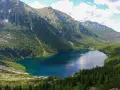 Morskie Oko, największe jezioro w Tatrach, otoczone zielonymi lasami i skalistymi szczytami.
