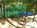 Dwie dziewczynki w słomkowych kapeluszach idą ścieżką nad turkusowe jezioro. Idealne miejsce na wycieczkę w jakie gory z dziecmi.
