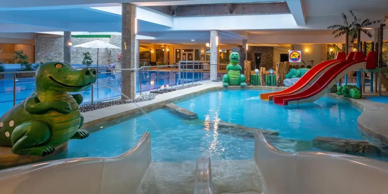 Wesołe dinozaury i zjeżdżalnie w aqua parku hotelowym zapraszają do zabawy w wodzie.