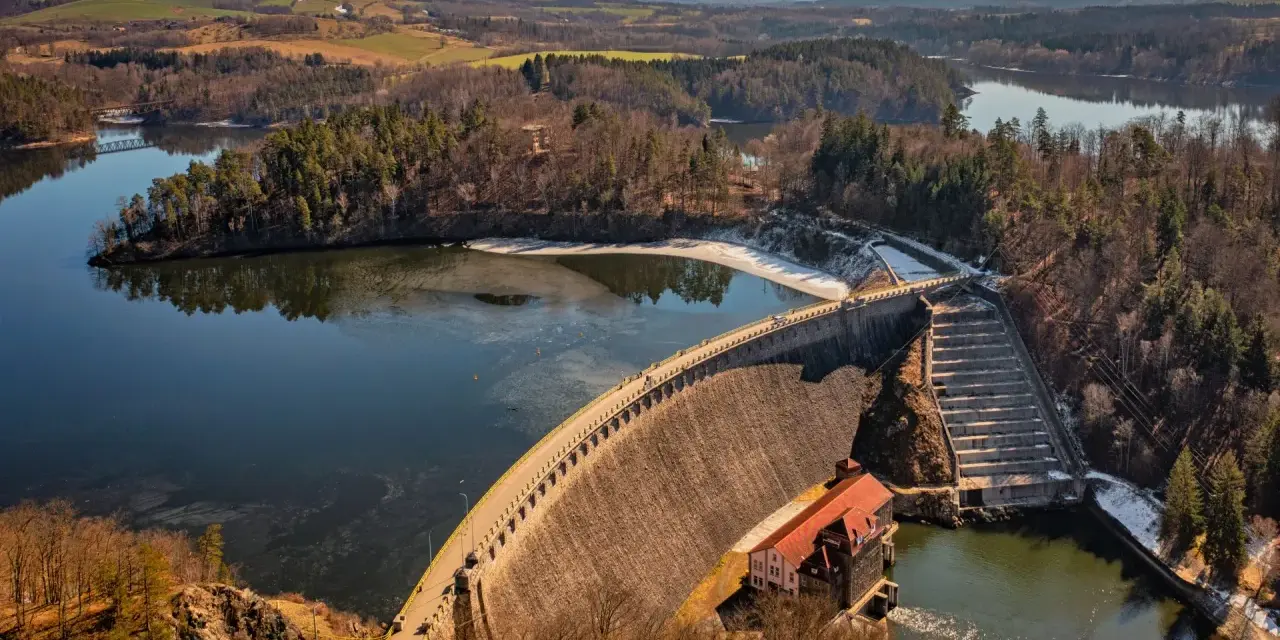 Zapora Pilchowice, malownicza trasa widokowa nad jeziorem. Widać most kolejowy i okoliczne wzgórza.