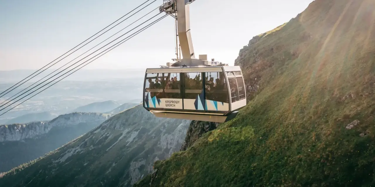 Kolejka na Kasprowy Wierch wwozi turystów na szczyt. Widok z wagonika zapiera dech w piersiach, ukazując malownicze Tatry.