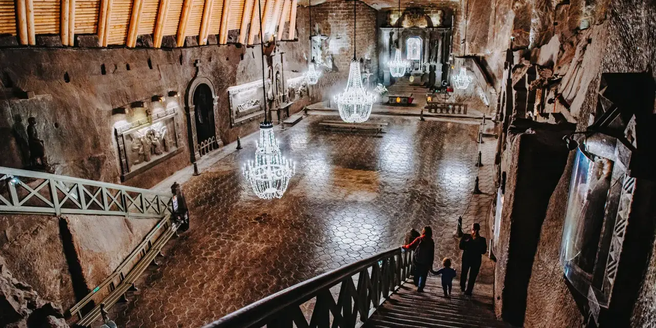 Wielka komora w kopalni soli w Wieliczce, z kryształowymi żyrandolami. Sprawdź kopalnia soli wieliczka cennik, by poznać ceny biletów.