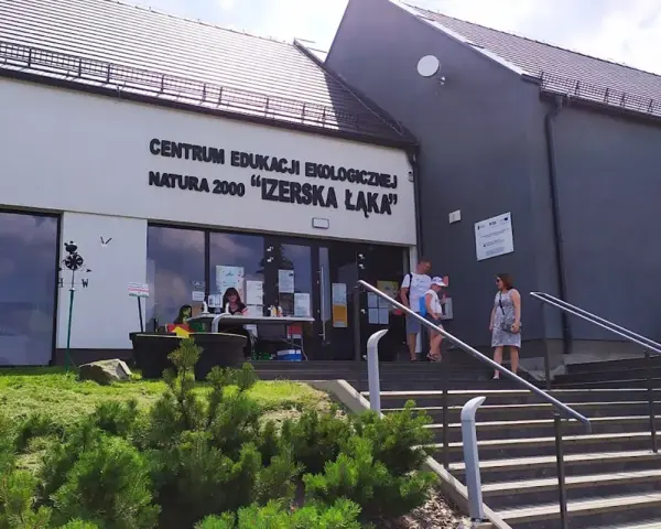 Centrum Edukacji Ekologicznej Natura 2000 "Izerska Łąka" zaprasza. Rodzina wchodzi po schodach do budynku.