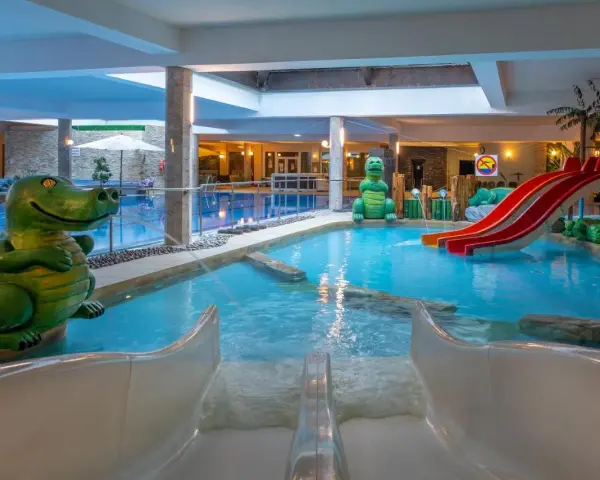 Wesołe dinozaury i zjeżdżalnie w aqua parku hotelowym zapraszają do zabawy w wodzie.