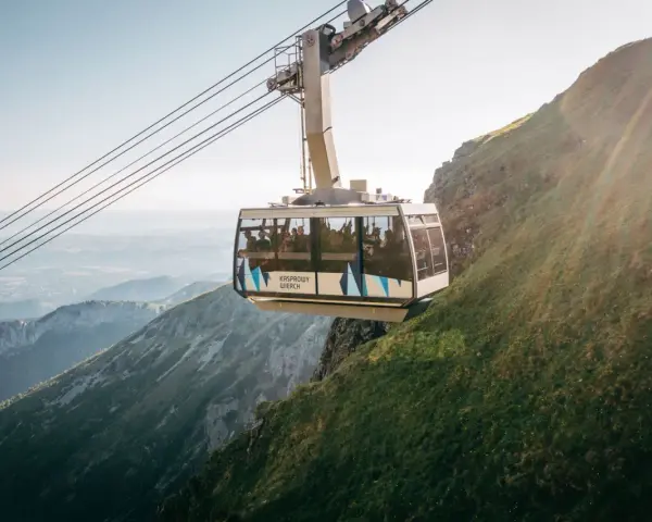 Kolejka na Kasprowy Wierch wwozi turystów na szczyt. Widok z wagonika zapiera dech w piersiach, ukazując malownicze Tatry.