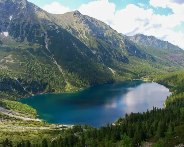 Morskie Oko, największe jezioro w Tatrach, otoczone zielonymi lasami i skalistymi szczytami.