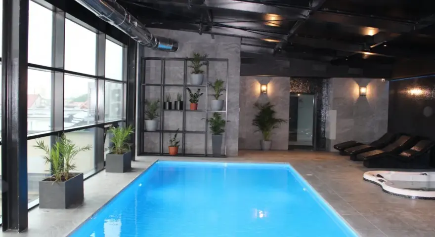 Nowoczesny hotel spa Białystok z basenem, jacuzzi i leżakami. Duże okna z widokiem na miasto.