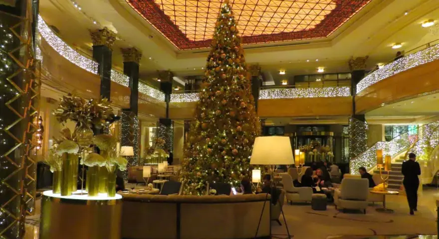 Elegancka wigilia w hotelu. Ogromna choinka, złote dekoracje i migoczące światełka tworzą magiczną atmosferę.