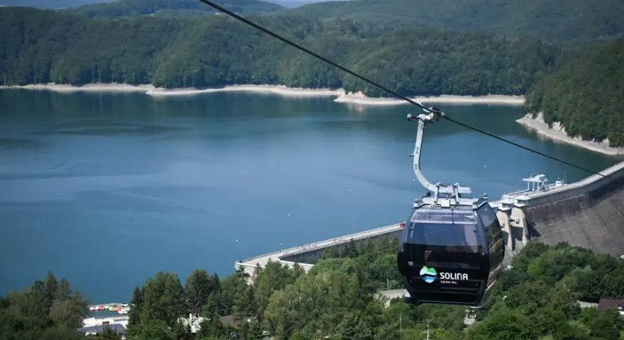 Kolejka linowa nad Soliną, idealna na podróż pociągiem w Bieszczady. Widok na zaporę i jezioro.
