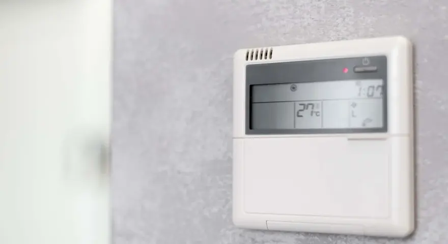 Panel klimatyzacji hotelowej pokazuje 27°C. Dowiedz się, jak ustawić klimatyzację w hotelu, by cieszyć się komfortem.