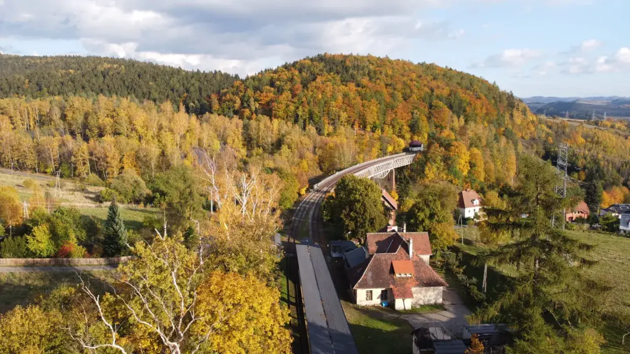 Jesienna panorama Gór Sowich z widokiem na wiadukt kolejowy i malownicze domy. Mapa atrakcji regionu.