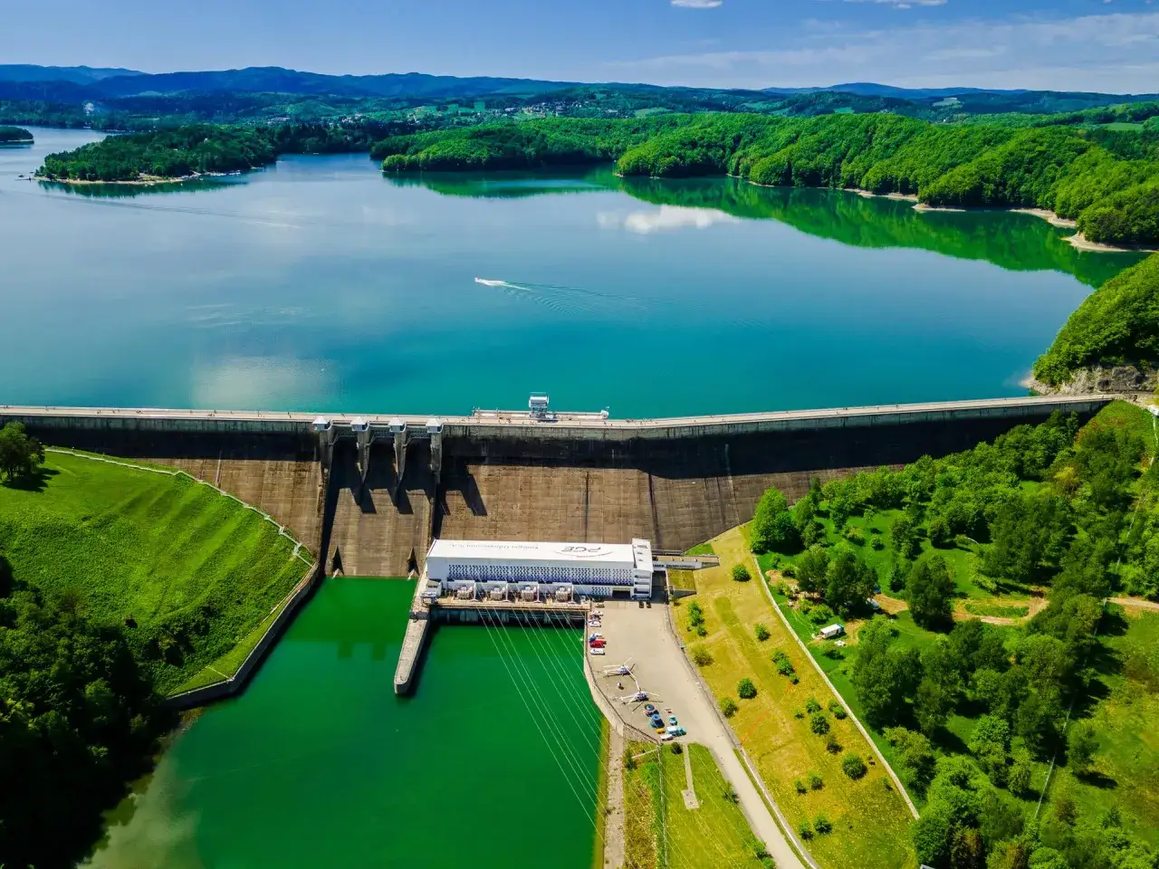 Zapora Solina z lotu ptaka, zielone wzgórza i turkusowa woda. Warto sprawdzić, czy zapora Solina bilety są dostępne online przed wizytą.